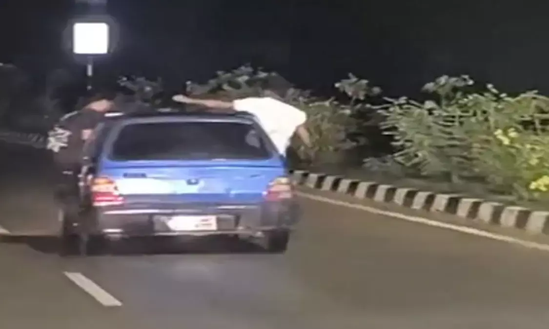 Youth performing stunts in a moving car