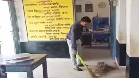 assistant teacher sweeping