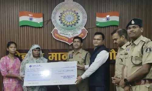 Bank employee giving a cheque of Rs 1 crore to the head constable