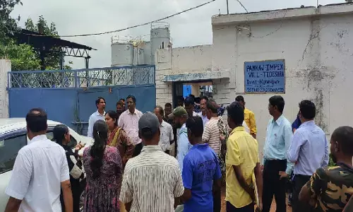 Officials standing outside the factory