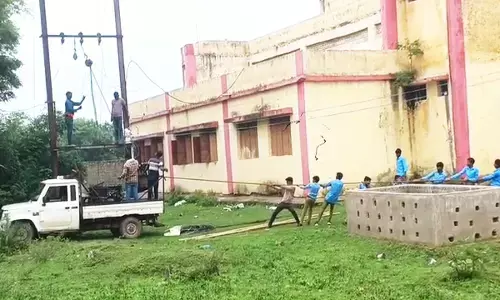 बच्चों से ट्रांसफार्मर खिंचवाते हुए कर्मचारी