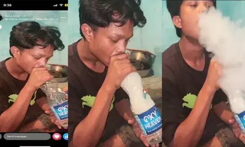 पानी के बोतल से गांजा पीते हुए युवक