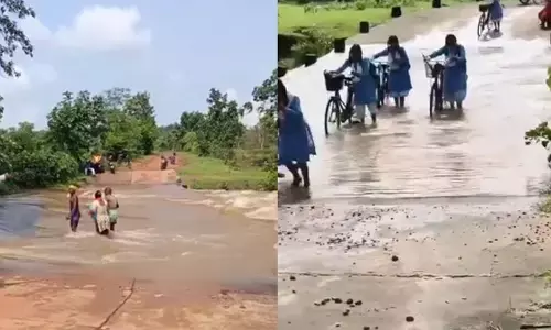 उफनते पुल को पार कर रहे स्कूली छात्र और ग्रामीण