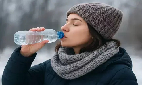 ठंड के मौसम में पानी पीती महिला