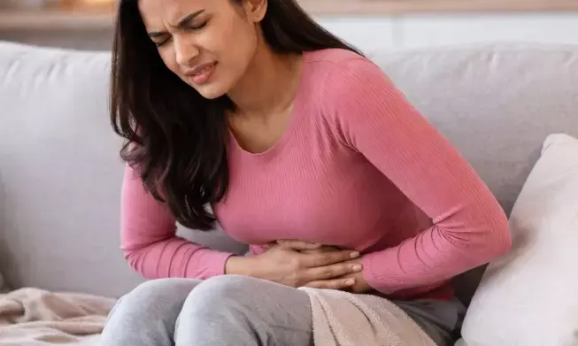 पीरियड्स के दर्द से परेशान महिला