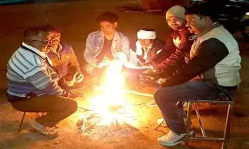 अलाव सेंकते लोग